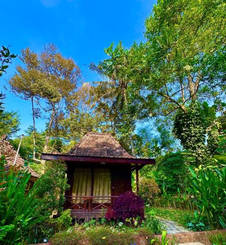 a small gazebo in the middle of a garden at Puunee Wild River Villa's Borobudur in Borobudur