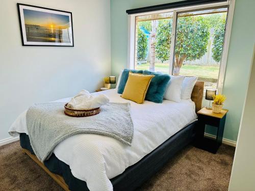 a bedroom with a large bed with a window at Ocean Breeze Family Getaway - Short drive to Beach, Wineries, Kids Golf & Adventure Park in Ocean Grove