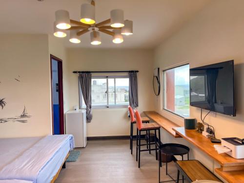 a bedroom with a bed and a desk with a computer at wow夢想家會館 in Green Island