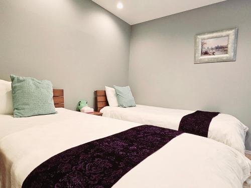 a bedroom with two beds with white sheets at Hanen半園 in Osaka