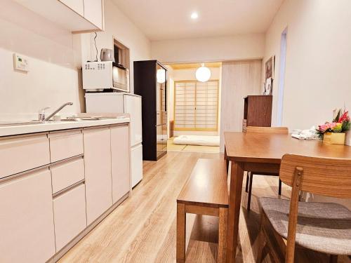 a kitchen and dining room with a table and a refrigerator at Hanen半園 in Osaka