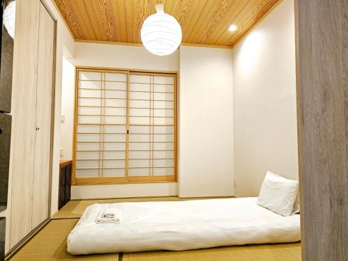 a room with a bed in the corner of a room at Hanen半園 in Osaka