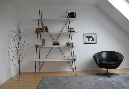 a black chair sitting in a room with shelves at Mosel - River - Quartier 31 in Lieser
