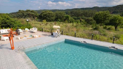 a swimming pool with a view of a house at Le Pavilion Pool Villa in Pohang