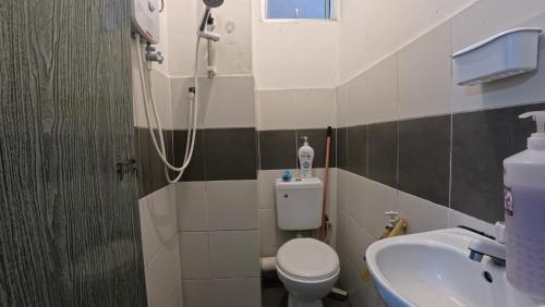 a bathroom with a shower and a toilet and a sink at Fizan Homestay in Tanah Rata