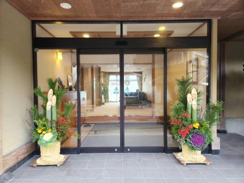 a glass door of a building with flowers at 坂本屋旅館 in Kyotango
