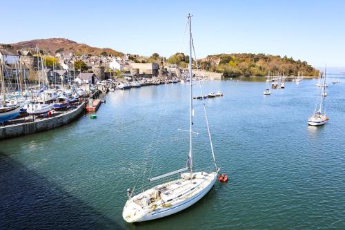 a sailboat is docked in a harbor with other boats at The Old Coach House in Conwy