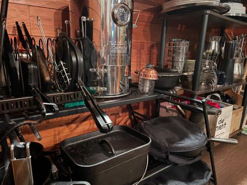 a kitchen with a bunch of utensils on a shelf at Pension KUROSHIOMARU in Setouchi