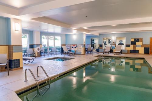 una piscina con sedie e tavoli in un edificio di Holiday Inn Express Hotel Raleigh Southwest by IHG a Raleigh