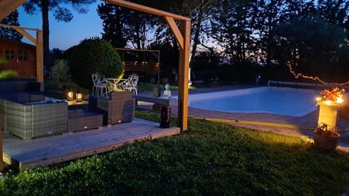 a backyard with a swimming pool at night at Gite le nid du canal in La Celle-sous-Gouzon