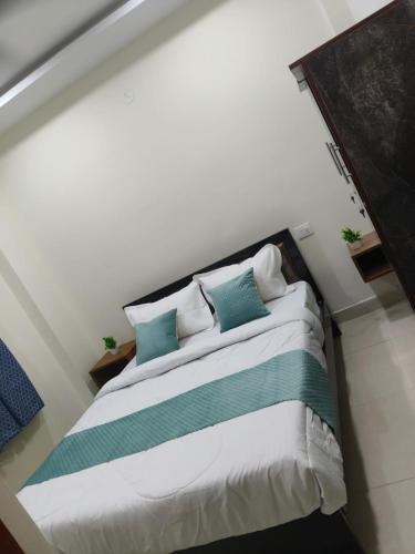 a bedroom with a bed with blue and white pillows at Next gen luxury colive and gest inn in Kondapur