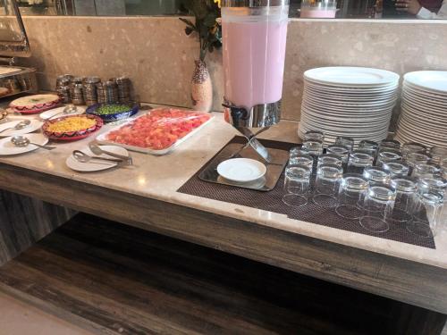 einen Tisch mit Tellern und Gläsern Essen drauf in der Unterkunft Cosmos Raj Plaza Jaipur in Jaipur