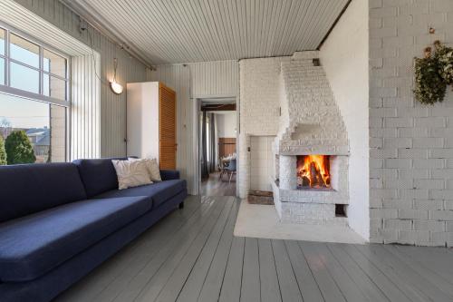 a living room with a blue couch and a fireplace at Künni Villa, saun ja mullivann in Viljandi