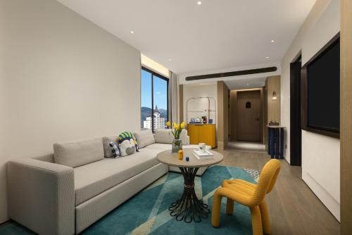 a living room with a couch and a table at voco Xishuangbanna Gaozhuang by IHG in Jinghong