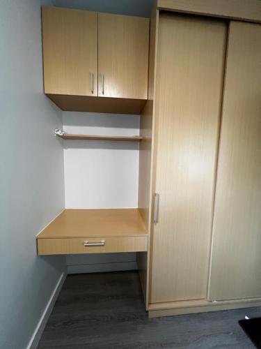 an empty closet with wooden cabinets in a room at Antara Residences in Talisay