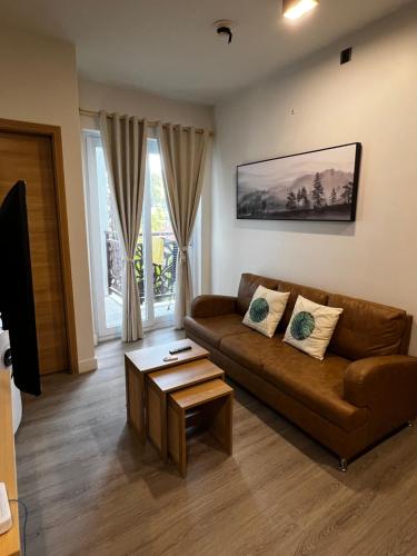 a living room with a brown couch and a table at Antara Residences in Talisay