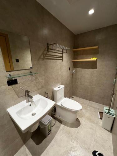 a bathroom with a white toilet and a sink at Antara Residences in Talisay