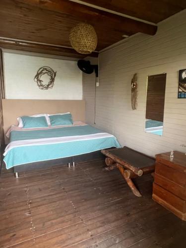 une chambre avec un lit et un parquet dans l'établissement El Arca, à Tintipan Island
