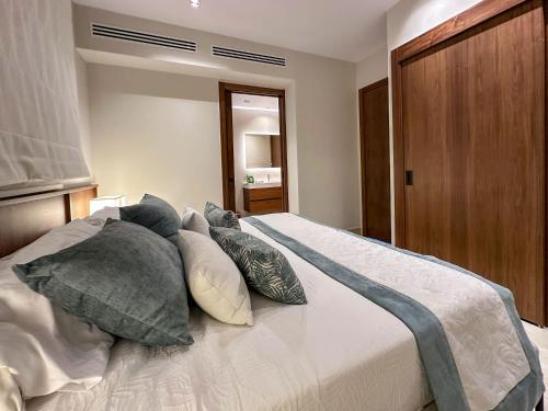 a bedroom with a bed with pillows on it at Marina Garden Cap Cana by Beach Homes Punta Cana in Punta Cana