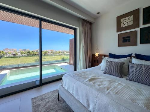 a bedroom with a large bed and a large window at Marina Garden Cap Cana by Beach Homes Punta Cana in Punta Cana