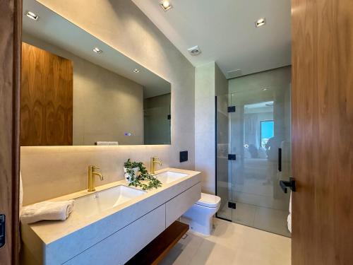 a bathroom with a sink and a toilet and a mirror at Marina Garden Cap Cana by Beach Homes Punta Cana in Punta Cana