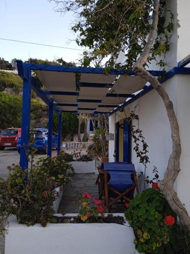 a blue pergola with a table and a chair at Kouvaras Apartments in Kýthira