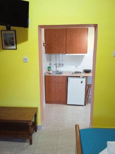 a kitchen with wooden cabinets and a white refrigerator at Kouvaras Apartments in Kýthira