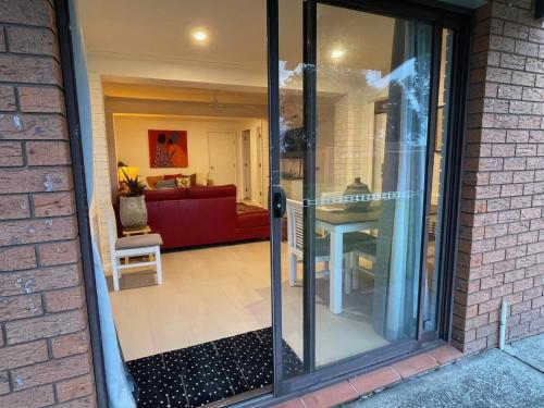 a sliding glass door leading into a living room at Beachfront Bliss on Collingwood Beach in Vincentia