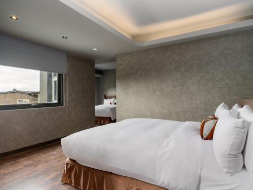 a bedroom with a large white bed and a window at Daybreak in Jiufen