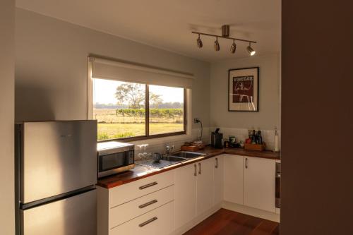 a kitchen with a stainless steel refrigerator and a window at Moodemere Lake House in Rutherglen