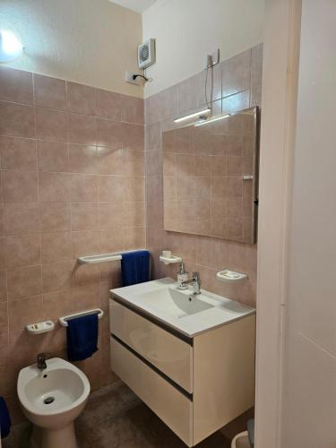 a bathroom with a sink and a toilet at La Rosa dei Venti B&B in Chia
