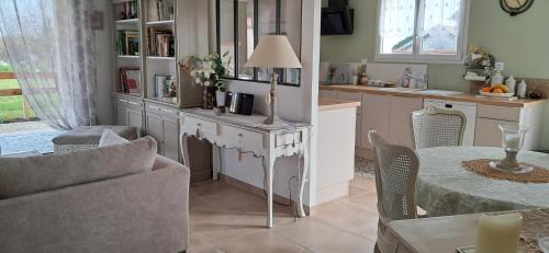 une cuisine avec une table et un salon dans l'établissement Le clos fleuri, à Arvert