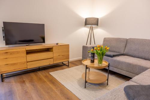un soggiorno con un divano e una TV di Ostseedomizil "Ankerbuk", Ferienwohnung Kormoran a Born