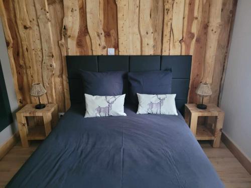 - une chambre avec un lit bleu et deux lampes dans l'établissement Gîte Forêt Vosgienne gitesdes2vallées, à Saint-Maurice-sur-Moselle