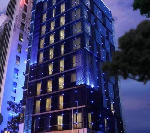 a tall building with blue lights on it at Alief hotel 88 in Sampal 2