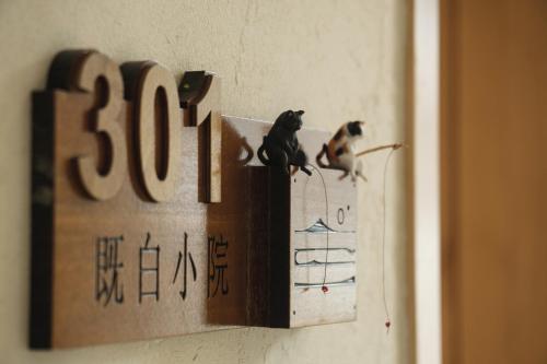 two birds sitting on top of a sign on a wall at The White Courtyard in Dali
