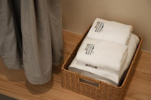 a basket filled with towels sitting on a wooden floor at The White Courtyard in Dali