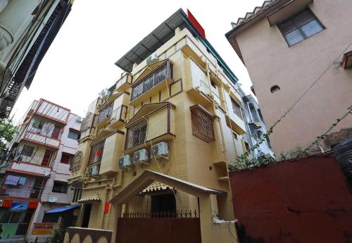 a yellow building next to a tall building at Hotel O Chinar in kolkata