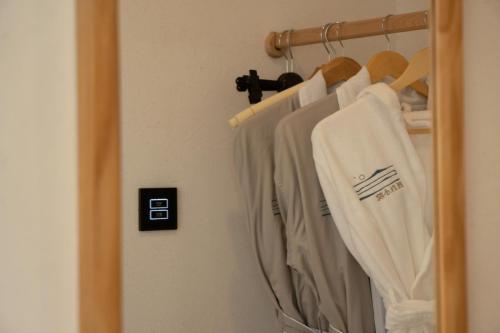 a closet with white shirts hanging on a rack at The White Courtyard in Dali