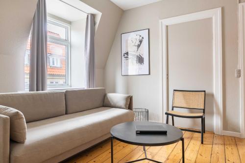 a living room with a couch and a table at Rustic & Cozy 2BR in Heart of CPH City by Strøget in Copenhagen