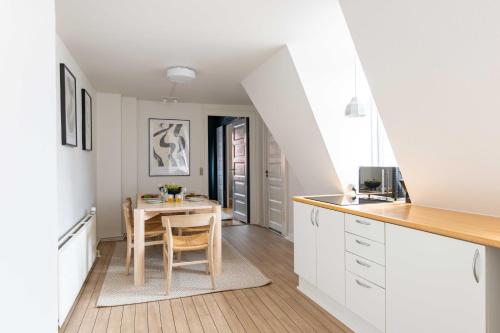a kitchen with a table and a dining room at Rustic & Cozy 2BR in Heart of CPH City by Strøget in Copenhagen