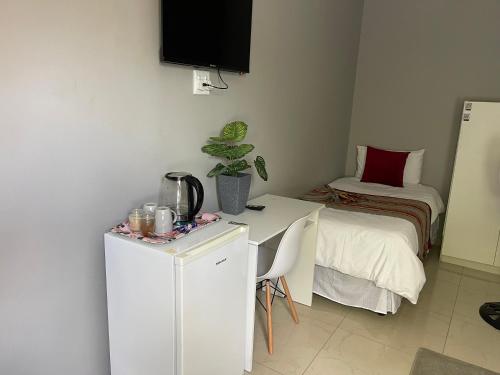 a small room with a table and a bed at Maita Guest in Cape Town
