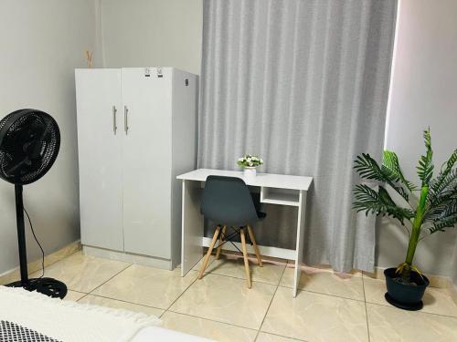 a desk and a chair in a room with a curtain at Maita Guest in Cape Town
