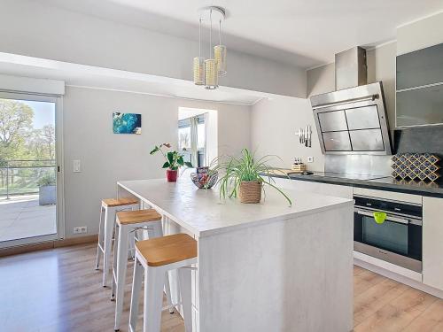- une cuisine avec un grand îlot de cuisine avec des tabourets dans l'établissement La terrasse du Canal, appartement pour 5 personnes, à Laredorte
