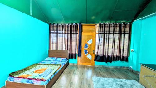 a small room with a bed and a door at Lamsang residency in Chug