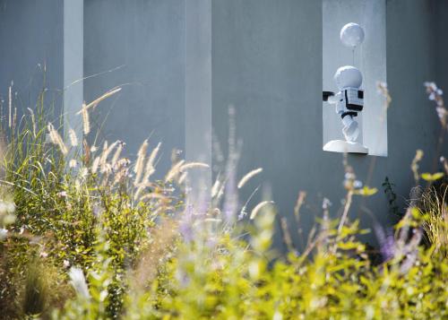 a toy robot sitting on a lightswitch in a garden at The White Courtyard in Dali