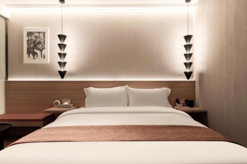 a bedroom with a large white bed and two tables at Chengdu Dafang Hotel 大方酒店 in Chengdu