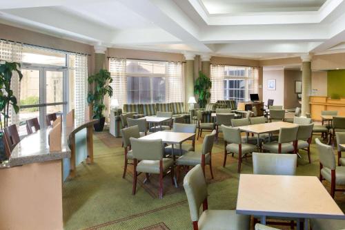 a dining room with tables and chairs and windows at La Quinta by Wyndham Austin Southwest in Austin