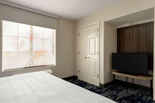 a bedroom with a bed and a flat screen tv at La Quinta by Wyndham Austin Southwest in Austin