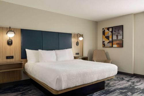 a hotel room with a large bed and a chair at La Quinta by Wyndham Austin Southwest in Austin